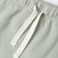 Close-up of a fern green fabric with a white drawstring on a white background