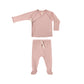 Pink baby outfit with long-sleeve top and footed pants on a white background