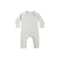 Knit infant jumpsuit with a subtle pattern with coconut buttons on a white background